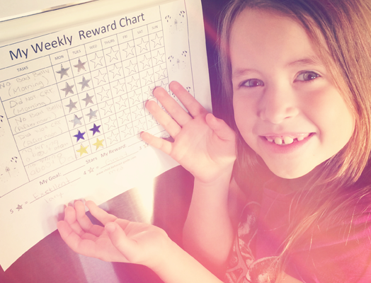 A Little Girl Showing her Rewards Chart With Stars