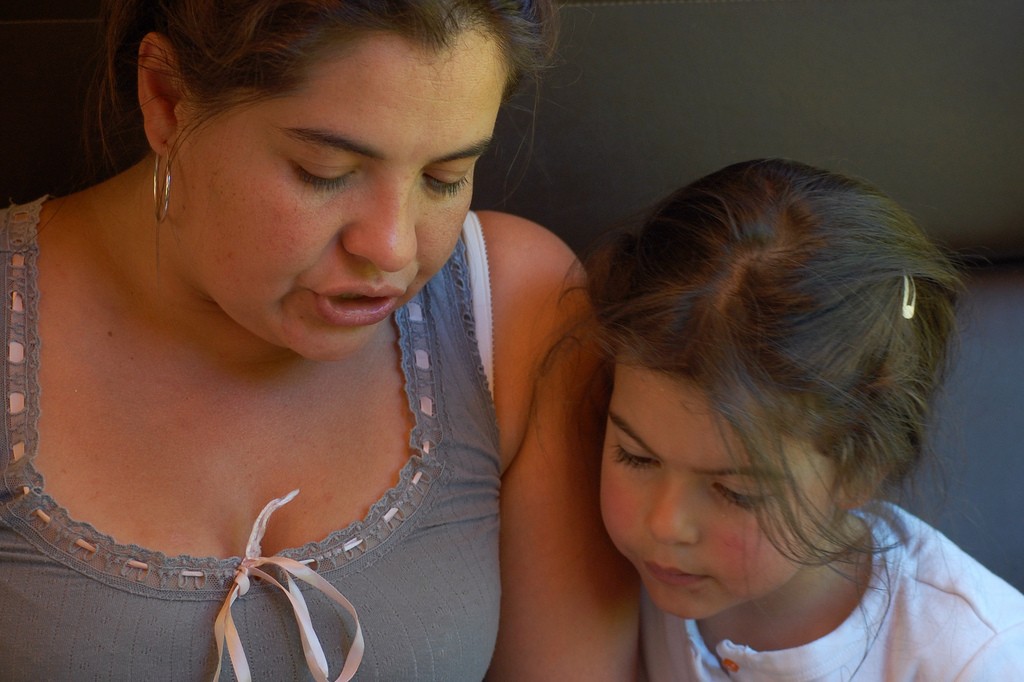 A Woman Teaching a Little Girl Beside