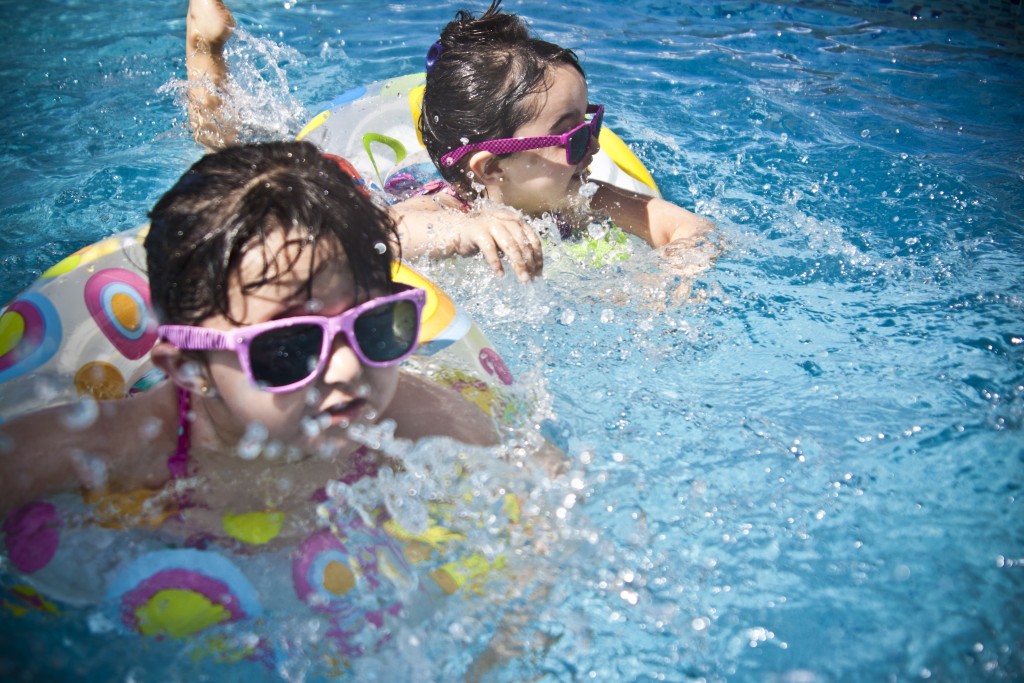 Two Children Swimming in a Pool of Water