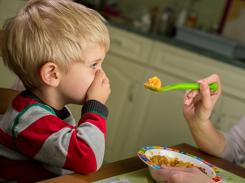 A Boy Closing Nose While Eating