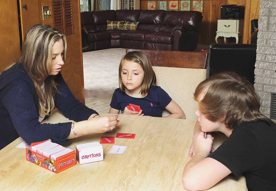 Two Children Playing With an Adult on a Table